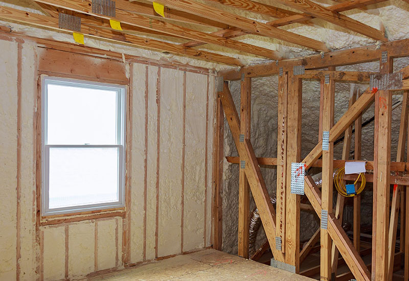 wall of an apartment attic, covered with insulation foam before